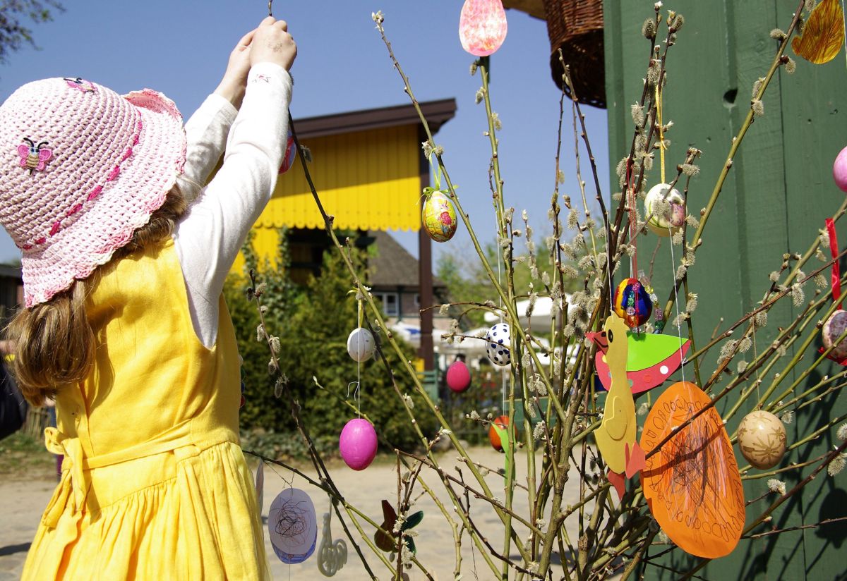 Kind schückt Strauch mit Ostereiern